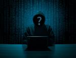 Grafika przedstawia hakera z zasłoniętą twarzą przy monitorze komputera (źródło: pixabay.com)